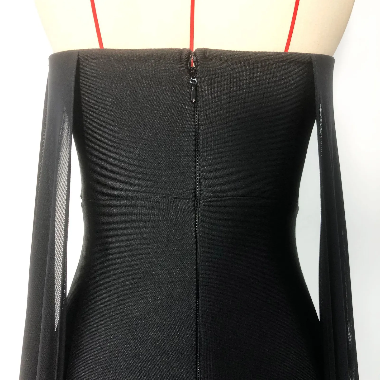 Close-up real photo of the back zipper and sheer mesh drapes on black bandage gown