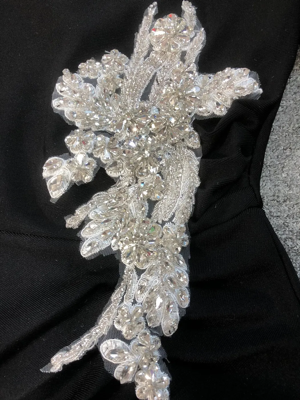 Close-up of the silver rhinestone appliqué on black one shoulder bandage maxi dress
