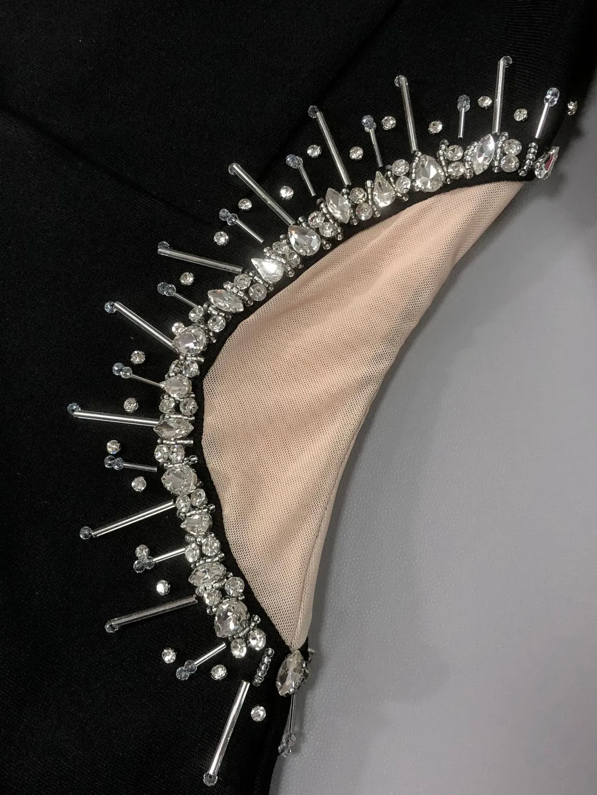 Close-up of the rhinestone fringe trim around the mesh side cut-out on black bandage maxi dress