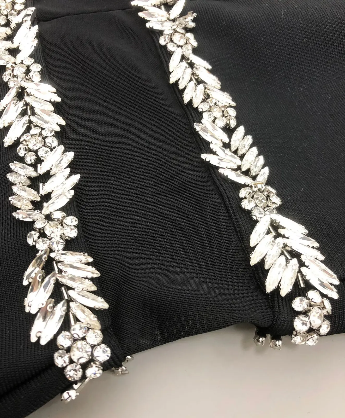 Close-up of the rhinestone trim on the mesh waist of black bandage maxi dress