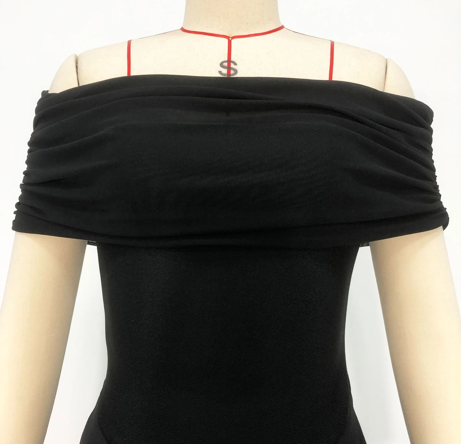 Close-up real photo of the black off shoulder ruched top on a mannequin