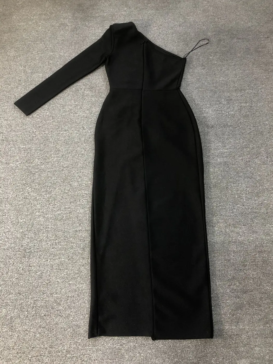 Flat lay of black one shoulder long sleeve bandage maxi dress