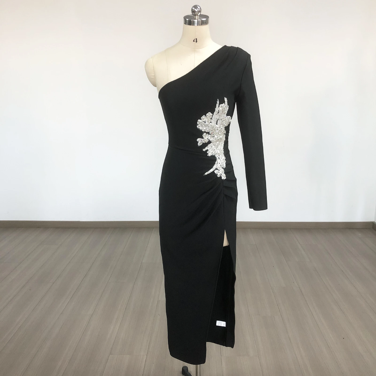 Real photo of black one shoulder long sleeve rhinestone slit bandage maxi dress on a mannequin