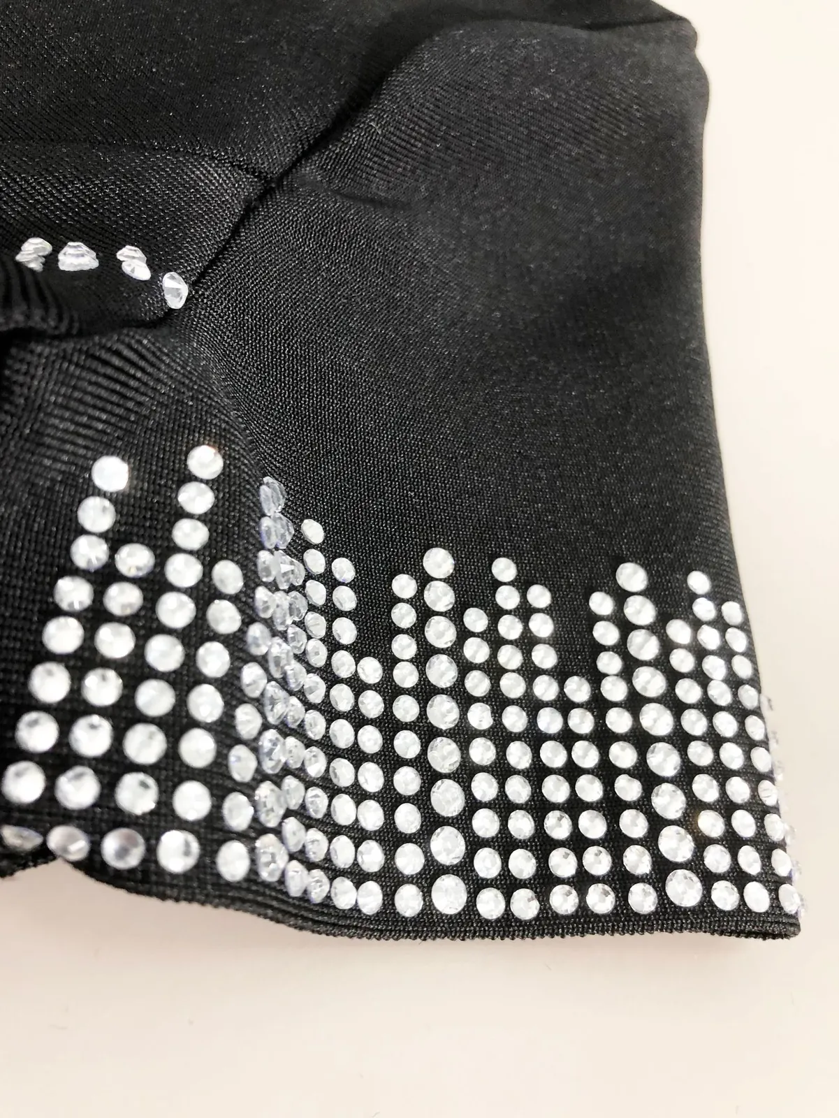 Close-up of rhinestone embellishment on the sleeve of black bandage mermaid dress