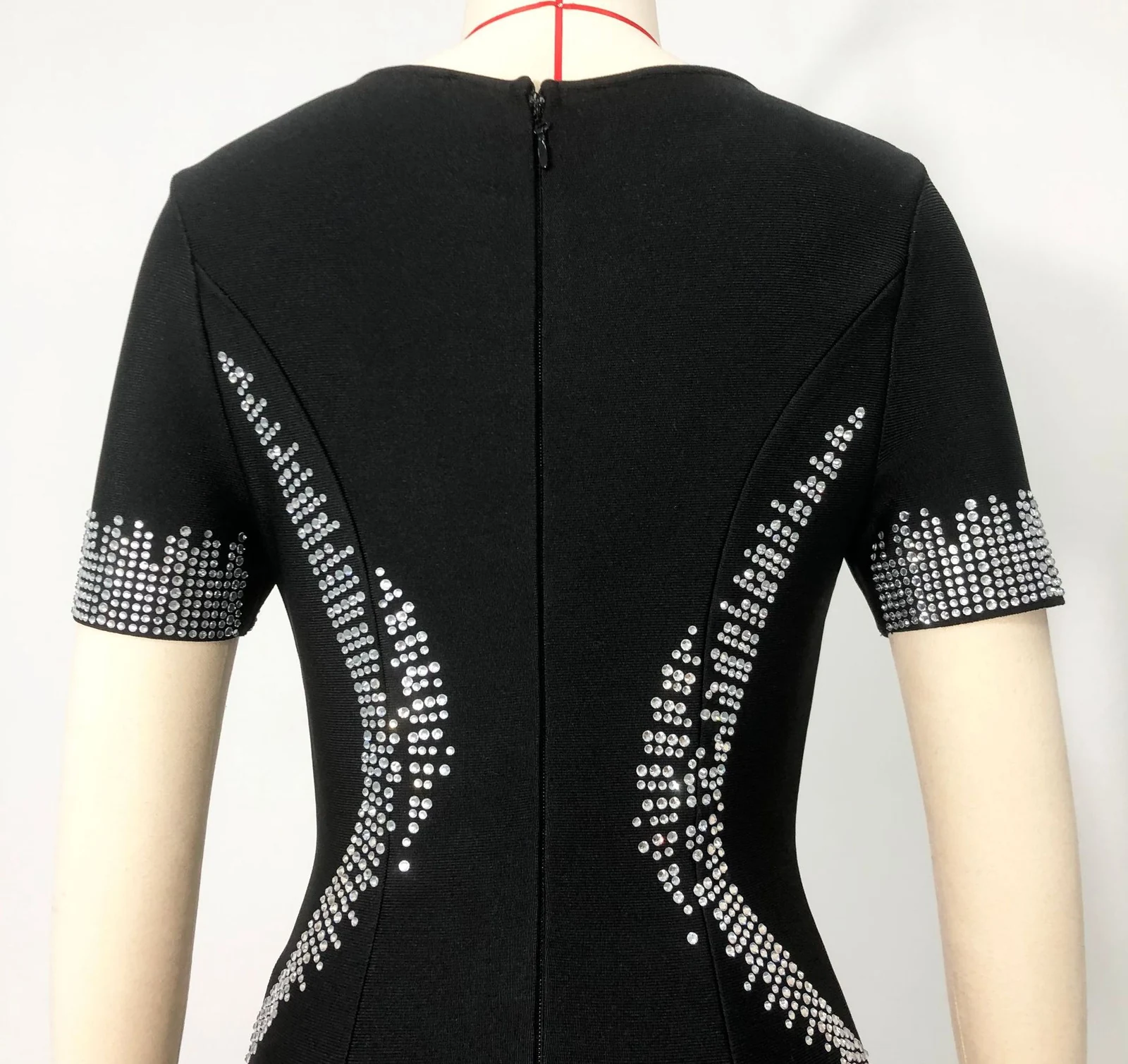 Real photo of the back of black short sleeve rhinestone bandage dress with zipper on a mannequin