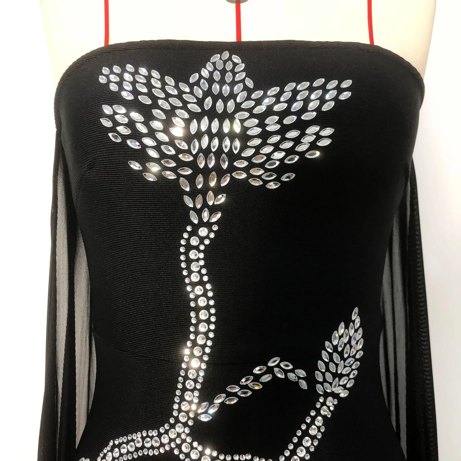 Close-up of the rhinestone floral embroidery on black strapless bandage gown bodice