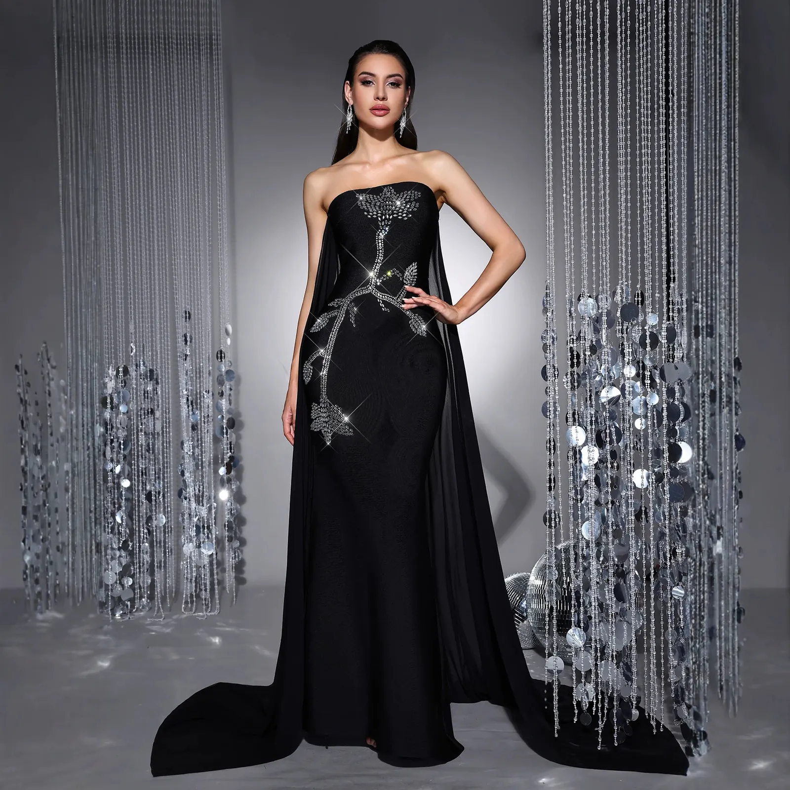 Full-length view of black strapless rhinestone embroidered bandage gown with mesh drapes