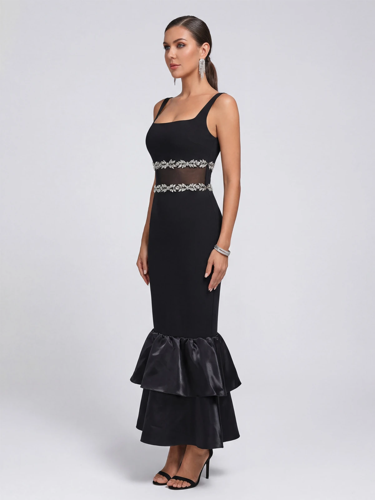 Side view of black square neck bandage maxi dress with tiered ruffle hem