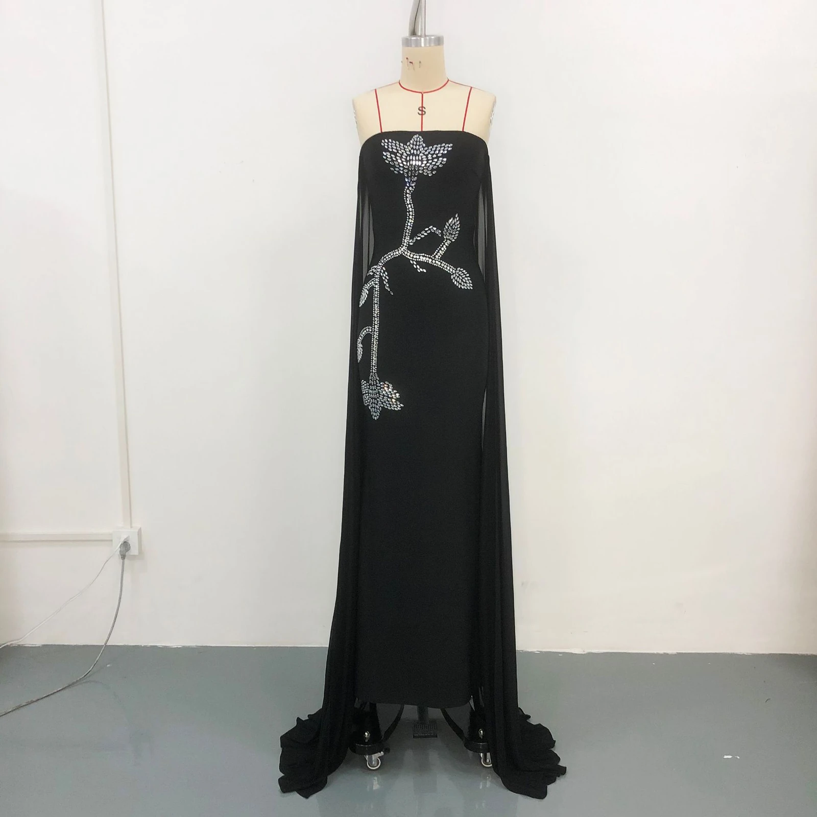 Real photo of black strapless rhinestone embroidered bandage gown with mesh drapes on a mannequin