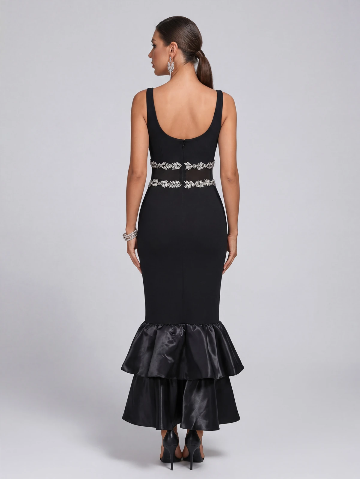 Back view of black bandage maxi dress with rhinestone waist band and tiered ruffle hem