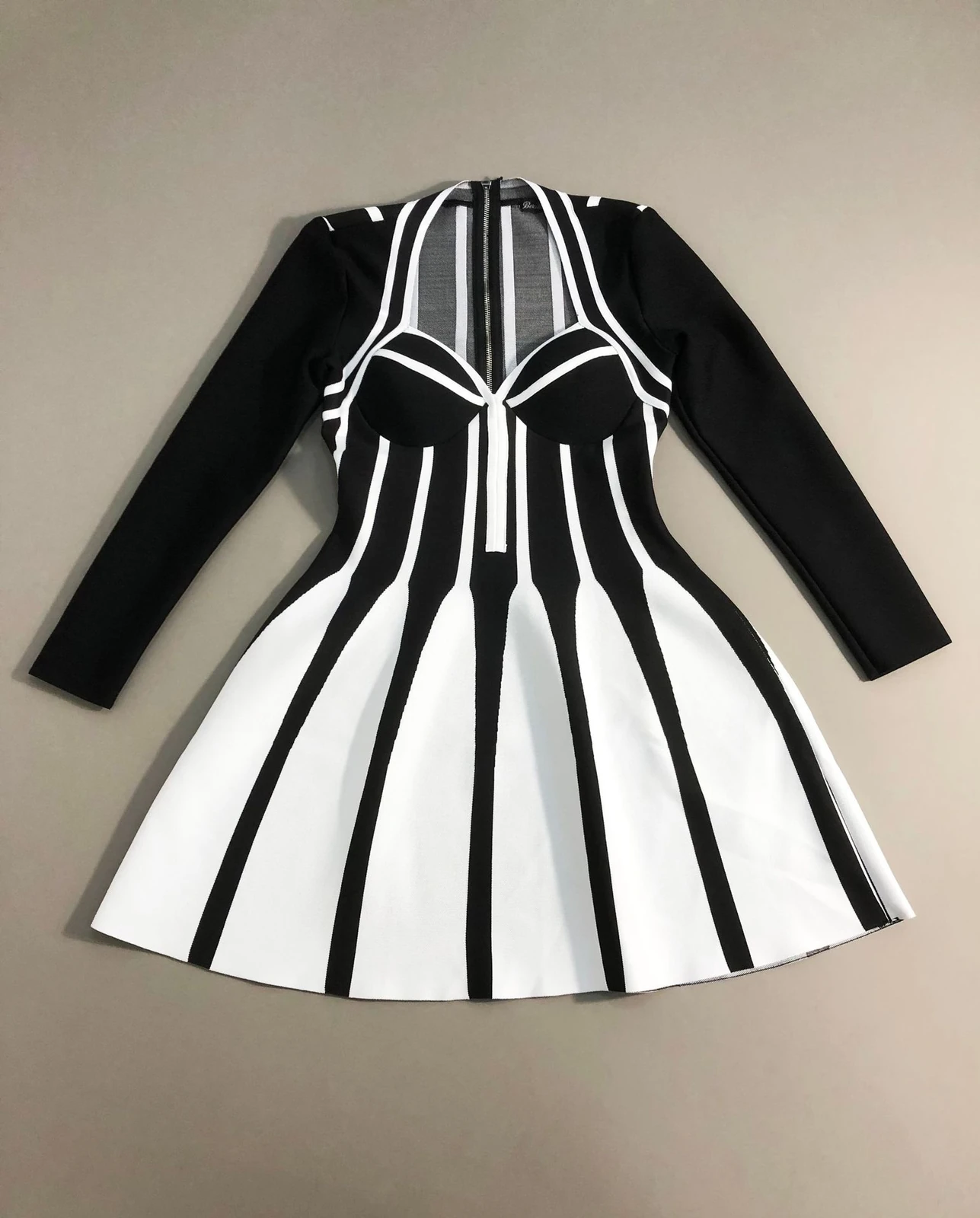 Flat lay of black and white stripe jacquard knit long sleeve puff mini dress