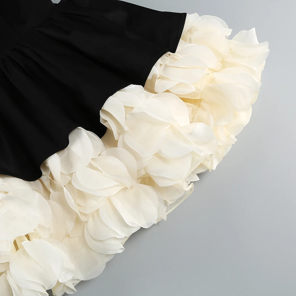 Close-up of cream ruffled petal hem under black puffball skirt