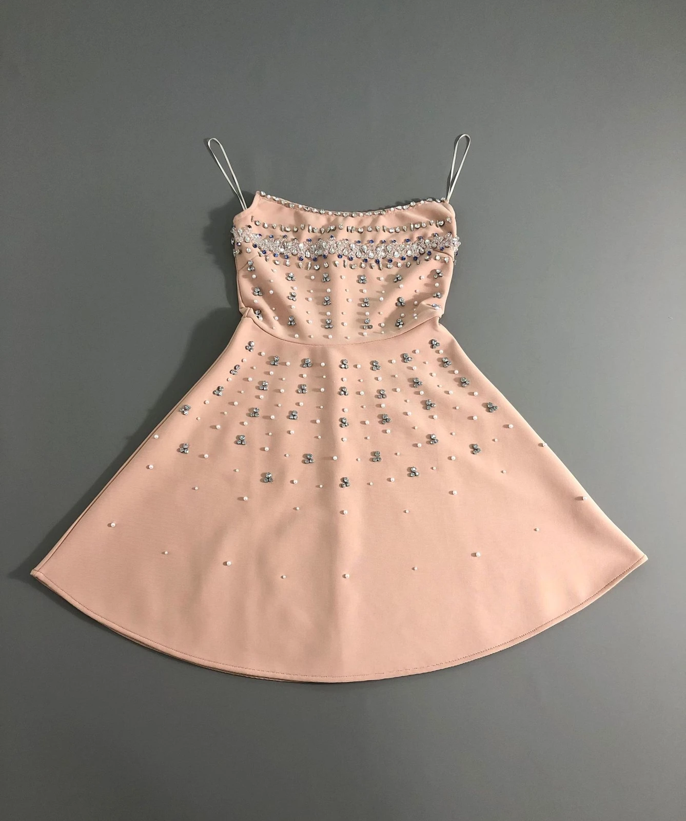 Flat lay of light orange rhinestone strapless A-line bandage mini dress