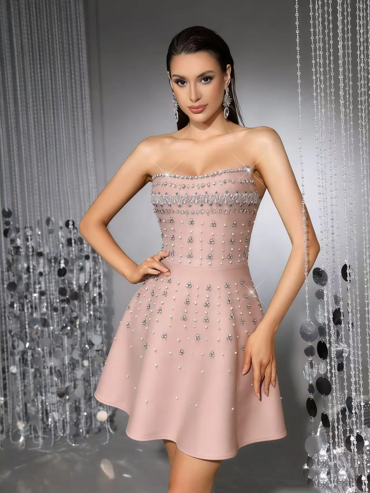 Model wearing light orange strapless A-line bandage mini dress with rhinestone embellishment