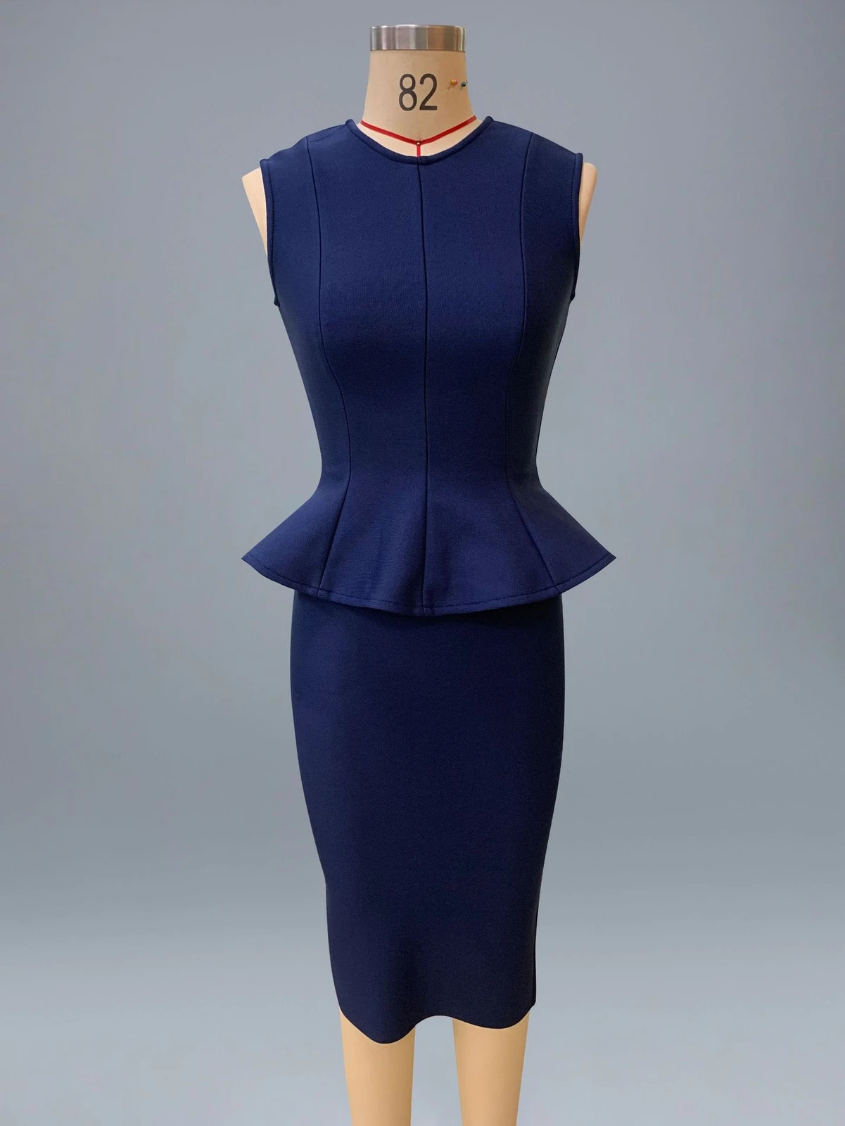 Real photo of navy sleeveless peplum ruffle top and bandage pencil skirt set on a mannequin