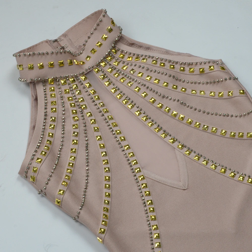 Close-up of gold-tone studs and sheer mesh on nude halter bandage dress