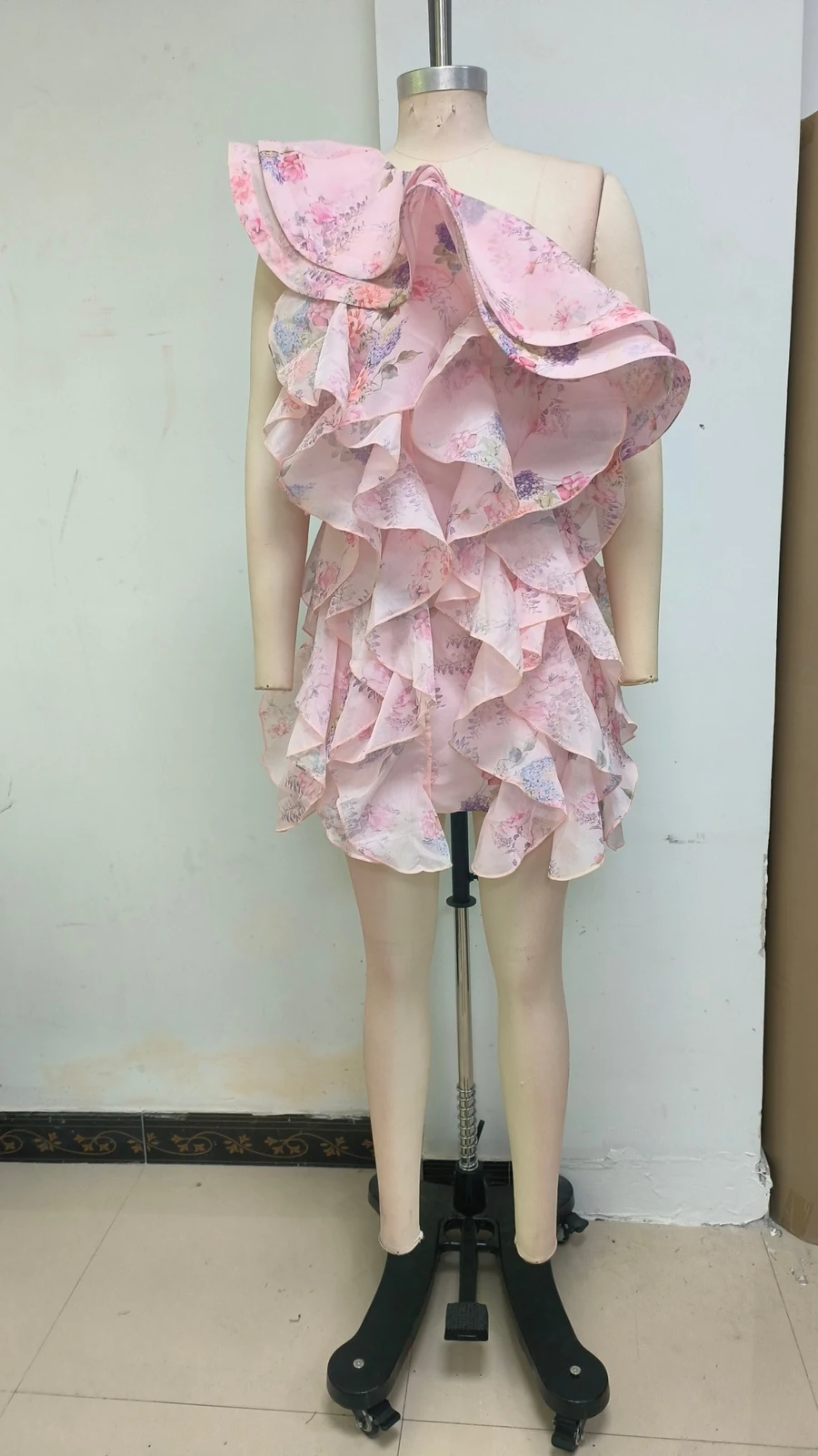 Real photo of pink one-shoulder floral ruffle mini dress on a mannequin