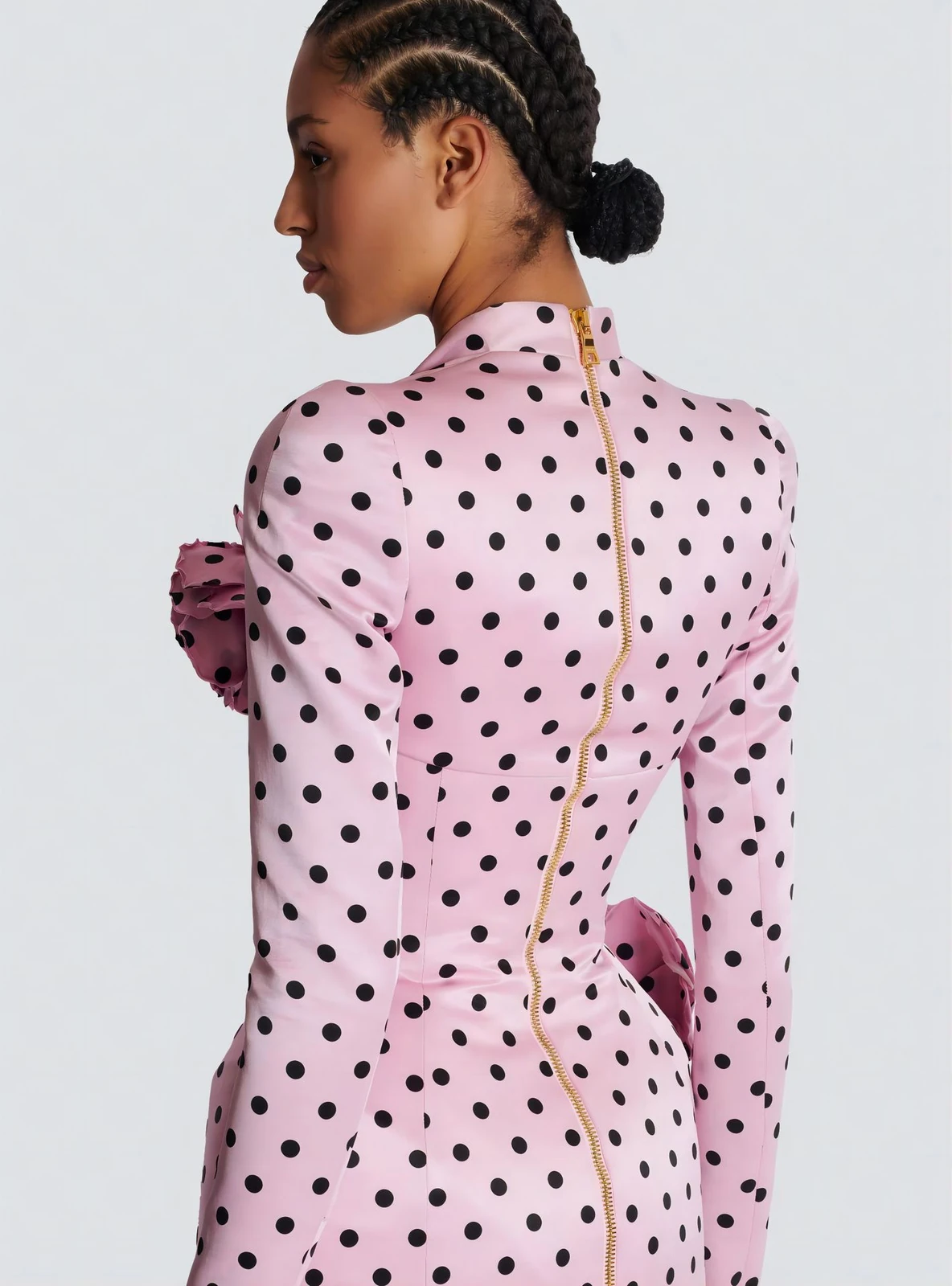 Close-up of back zipper and rose detail on pink polka dot long sleeve mini dress