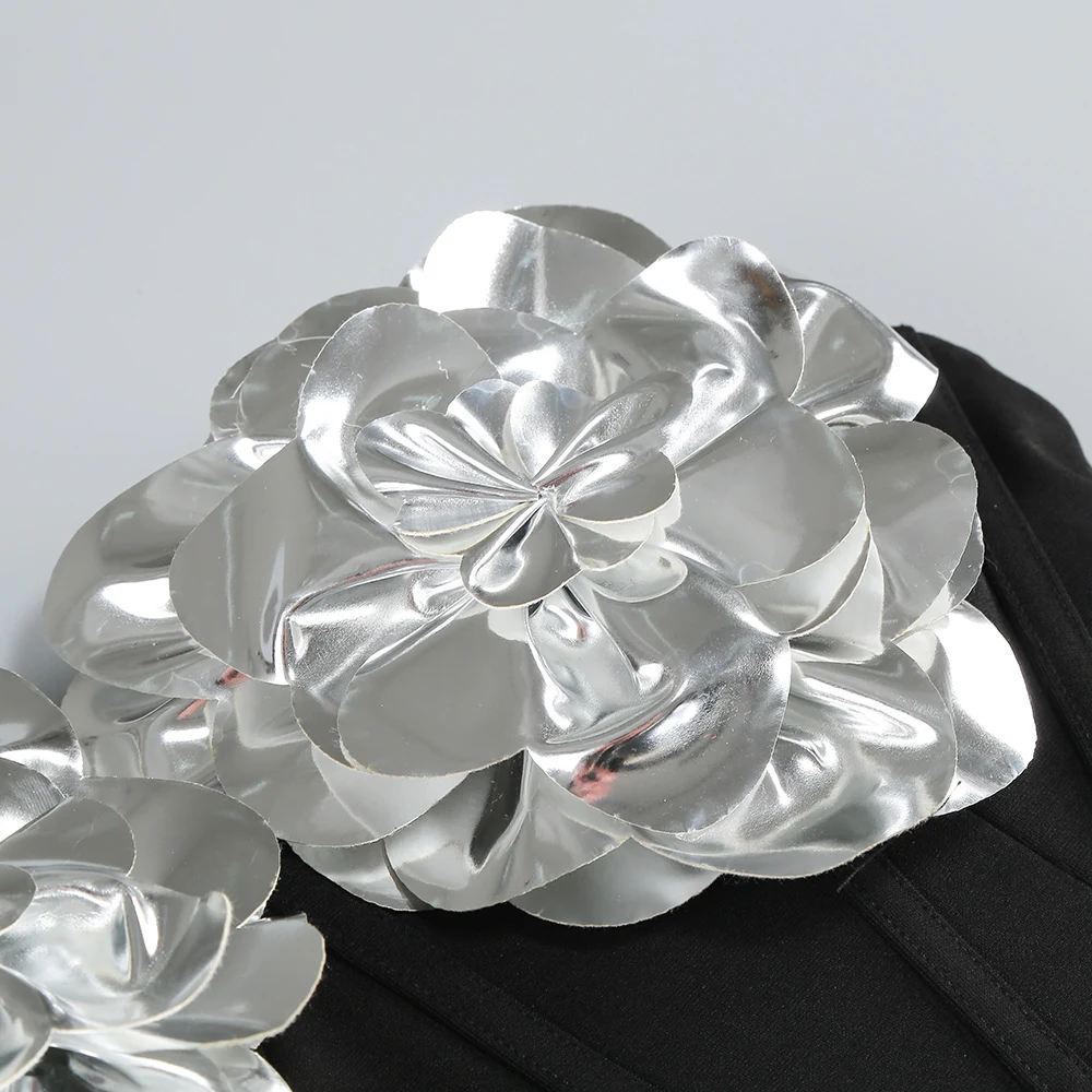 Close-up of silver 3D flower appliqué on black strapless dress