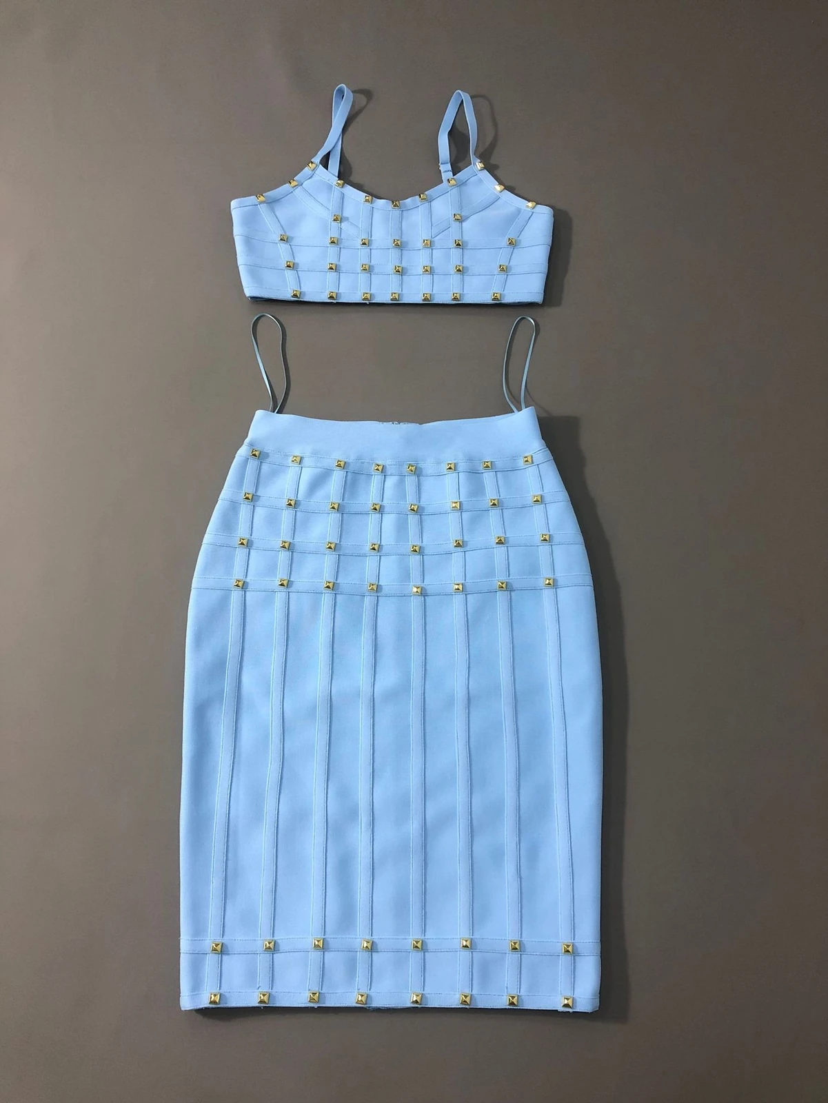 Flat lay of sky blue studded cami crop top and bandage pencil skirt two piece set