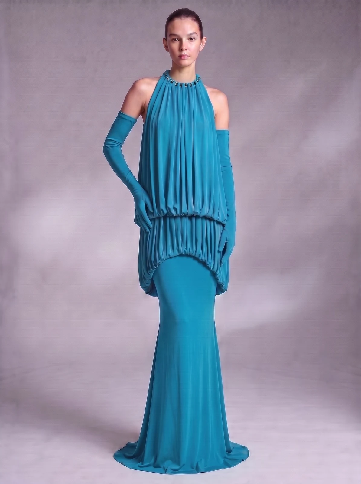 Model wearing turquoise halter draped blouson mermaid maxi dress with gloves, front view