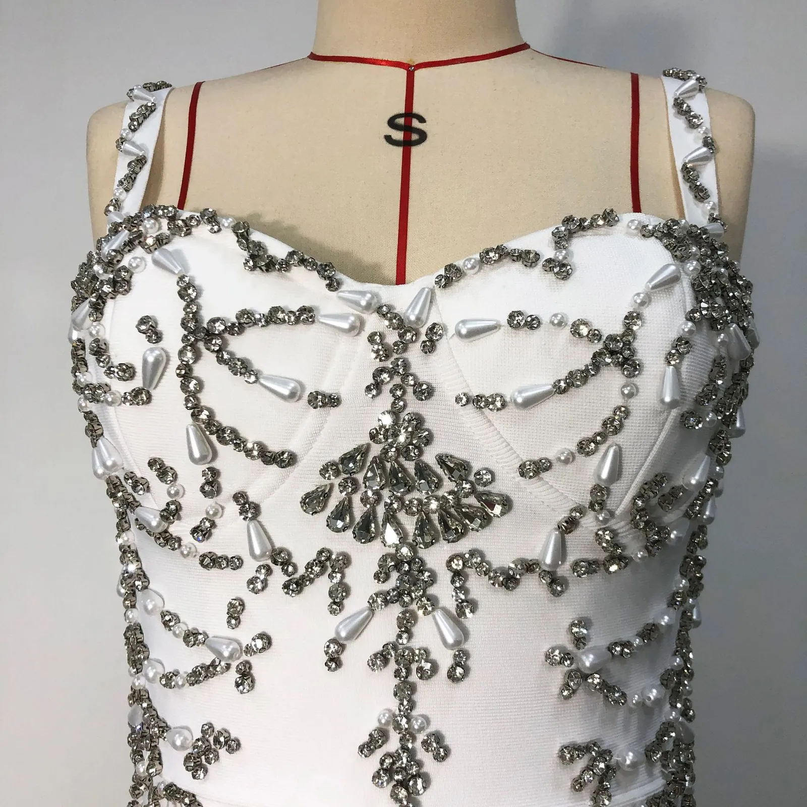 Close-up real photo of the silver beaded bodice on white spaghetti strap bandage maxi dress