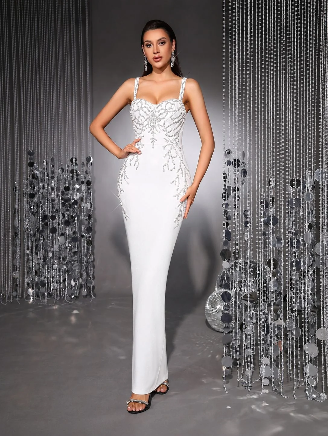 Model wearing white spaghetti strap bandage maxi dress with beaded embellishment, front view