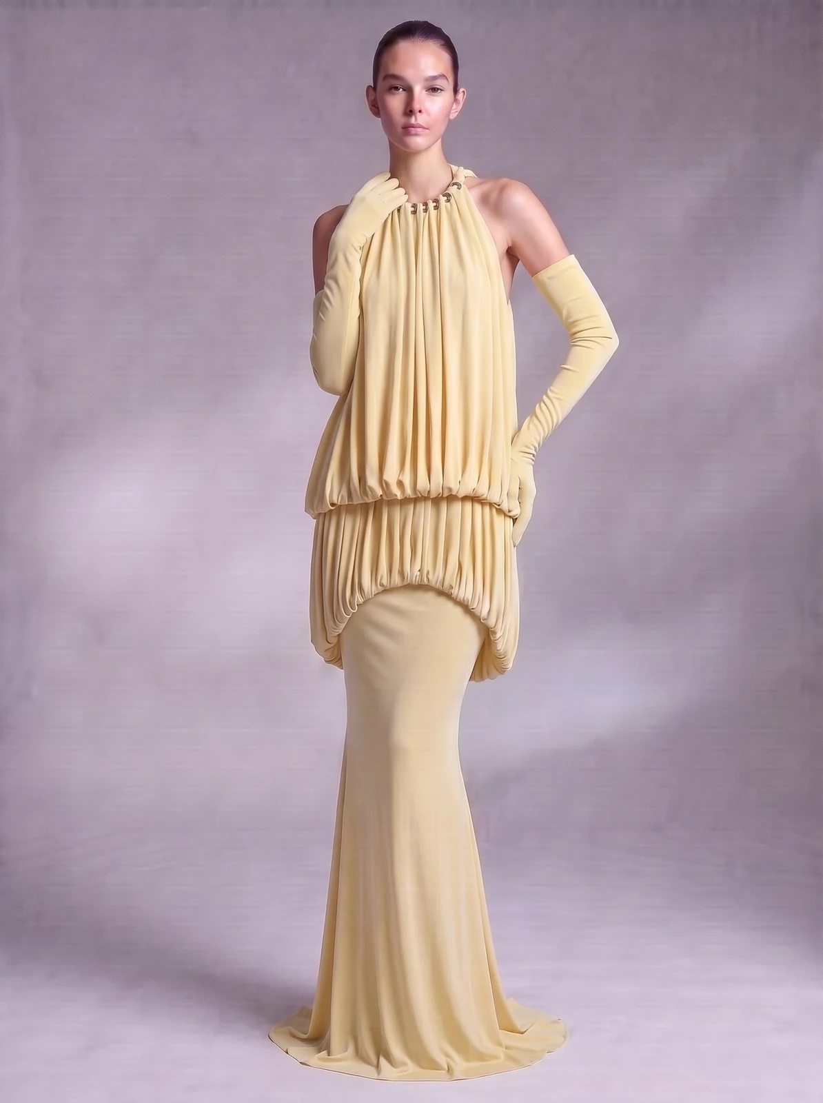 Model wearing yellow halter draped blouson mermaid maxi dress with gloves, front view