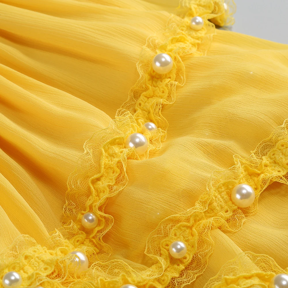 Close-up of pearl-trimmed ruffles on yellow strapless high-low ruffle maxi dress